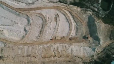 Loader loading sand into heavy dump truck at the opencast mining quarry. Dump truck transports sand in open pit mine. Quarry in which sand and gravel is excavated from the ground