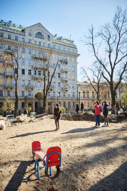 Kyiv, Ukrayna - 16 Ekim 2022: Başkentin merkezindeki bir çocuk parkında Rus roketinin patlamasından kaynaklanan bacanın yakınındaki insanlar