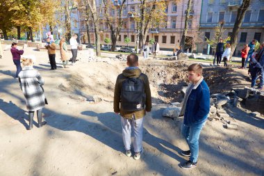 Kyiv, Ukrayna - 16 Ekim 2022: Başkentin merkezindeki bir çocuk parkında Rus roketinin patlamasından kaynaklanan bacanın yakınındaki insanlar
