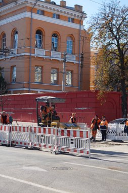 Kyiv, Ukrayna - 16 Ekim 2022: Kamu hizmetleri, Taras Shevchenko Ulusal Üniversitesi yakınlarındaki Öğretmenler Evi yakınlarındaki hasarlı bir yol bölümünü onarıyor.