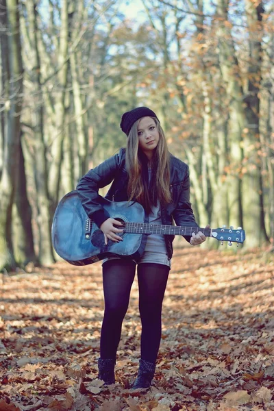 Chica con guitarra en el parque de otoño — Foto de Stock