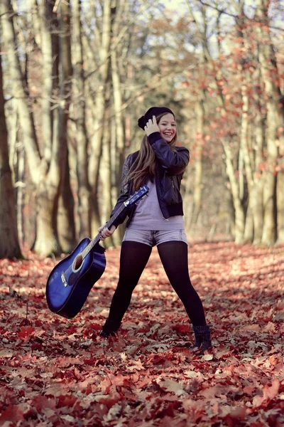 Dziewczyna z gitara w parku jesień — Zdjęcie stockowe