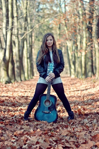 Девушка с гитарой в осеннем парке — стоковое фото