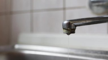 Water drops from an old faucet with limestone, save water concept with copy space