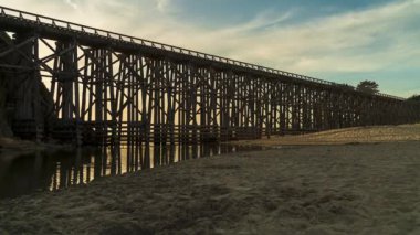 Gün batımları Pudding Creek Trestle Köprüsü, Fort Bragg, Kaliforniya, ABD 'de iken insanlar sahilde köprüden geçiyorlar.
