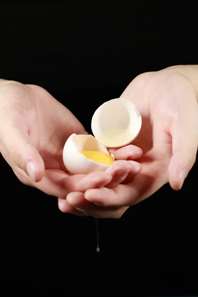 Avuçlarında kırılmış bir tavuk yumurtası.