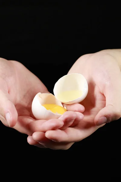 Avuçlarında kırılmış bir tavuk yumurtası.