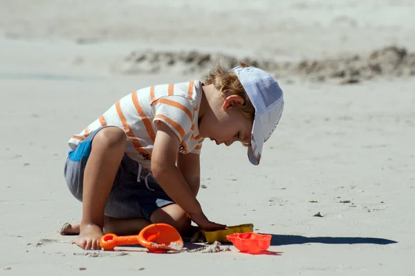 Un niño se prepara para construir un castillo de arena en una playa —  Fotos de Stock