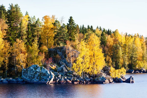Golden autumn forest and large rocks by a lake — Stock Photo, Image
