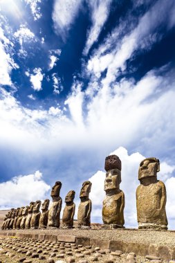 Moais standing on ahu with dramatic clouds in background in Easter Island clipart