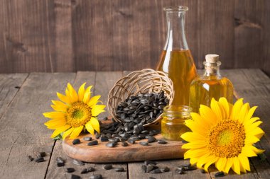 Geleneksel ahşap arka planda tohumları olan ayçiçeği yağı. 