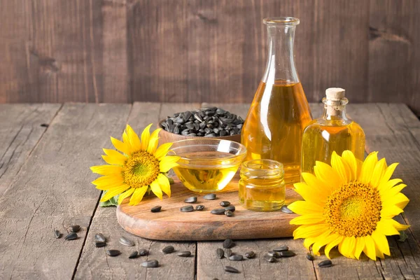 Geleneksel ahşap arka planda tohumları olan ayçiçeği yağı. 