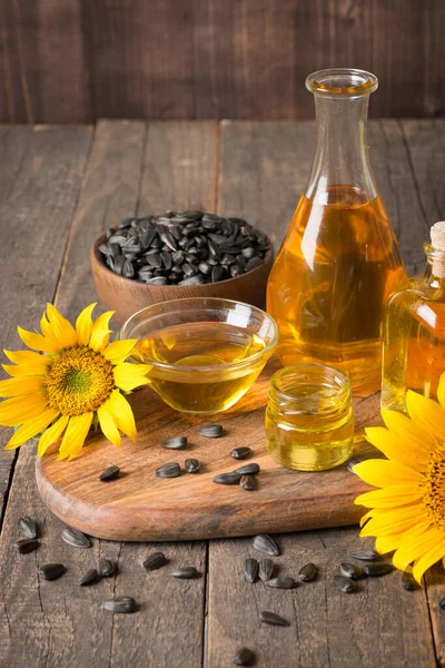 Geleneksel ahşap arka planda tohumları olan ayçiçeği yağı. 