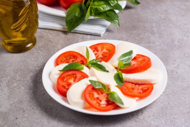 Caprese salatası olgun domates, fesleğen, buffalo mozzarella peyniri ile yakın çekim fotoğraf. İtalyan ve Akdeniz gıda kavramı. Taze ve sağlıklı organik yemek. Starter ve antipasti. 