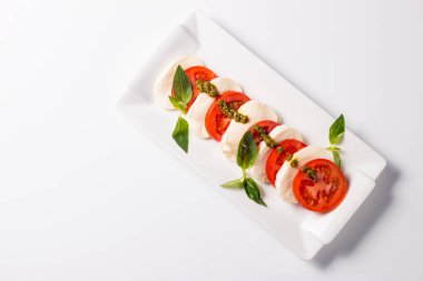 Caprese salatası olgun domates, fesleğen, buffalo mozzarella peyniri ile yakın çekim fotoğraf. İtalyan ve Akdeniz gıda kavramı. Taze ve sağlıklı organik yemek. Starter ve antipasti. 
