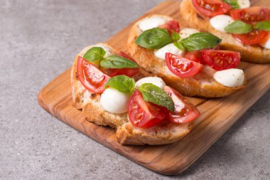 Domates, fesleğen ve peynir taze Caprese Bruschetta. İtalyan mezesi, sebzeli pandispanya ızgara ciabatta ve baget ekmekli yağ. Sandviç..