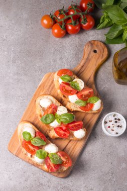 Domates, fesleğen ve peynir taze Caprese Bruschetta. İtalyan mezesi, sebzeli pandispanya ızgara ciabatta ve baget ekmekli yağ. Sandviç..