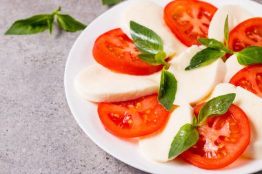 Caprese salatası olgun domates, fesleğen, buffalo mozzarella peyniri ile yakın çekim fotoğraf. İtalyan ve Akdeniz gıda kavramı. Taze ve sağlıklı organik yemek. Starter ve antipasti. 