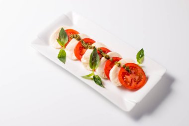 Caprese salatası olgun domates, fesleğen, buffalo mozzarella peyniri ile yakın çekim fotoğraf. İtalyan ve Akdeniz gıda kavramı. Taze ve sağlıklı organik yemek. Starter ve antipasti. 