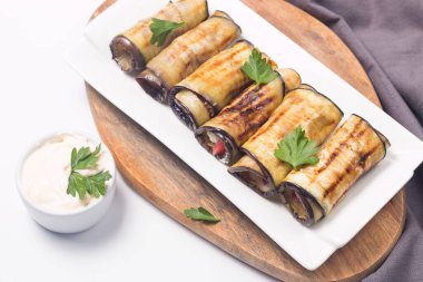 Baked grilled eggplant rolls with cottage cheese, tomatoes and sour cream. Georgian cuisine. 