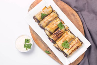 Baked grilled eggplant rolls with cottage cheese, tomatoes and sour cream. Georgian cuisine. 