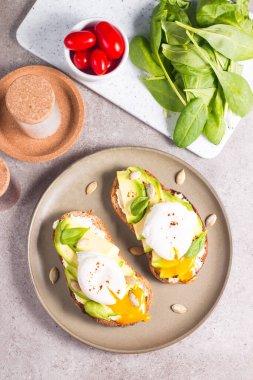 Avokado, krem peynirli tost çavdar ekmeği ve haşlanmış yumurta. Sağlıklı kahvaltı konsepti için açık sandviç..