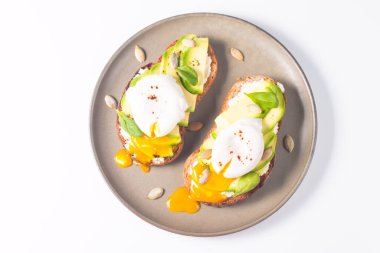 Avokado, krem peynirli tost çavdar ekmeği ve haşlanmış yumurta. Sağlıklı kahvaltı konsepti için açık sandviç..