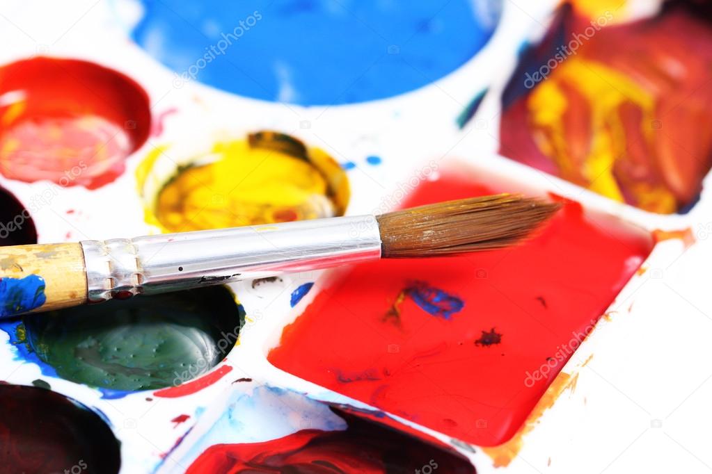 artists palette with various colour paints and brush