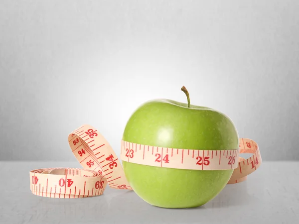 Green apples measured the meter on white — Stock Photo, Image