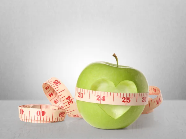 Green apples measured the meter on white — Stock Photo, Image