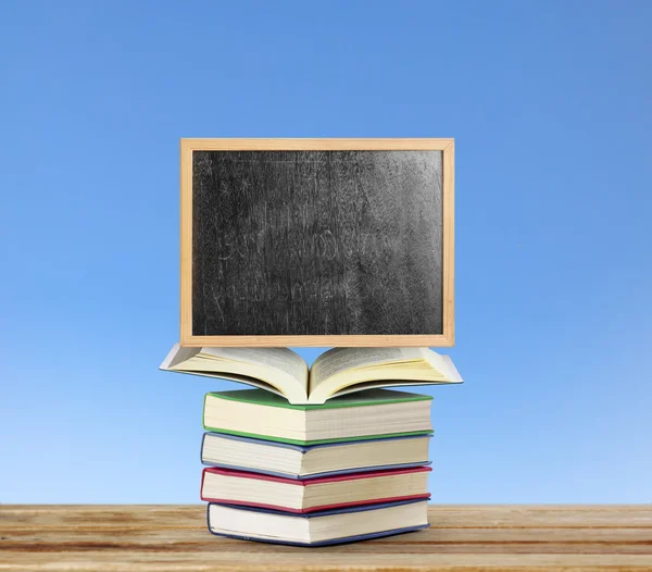 Blackboard on book  with wooden frame — Stock Photo, Image