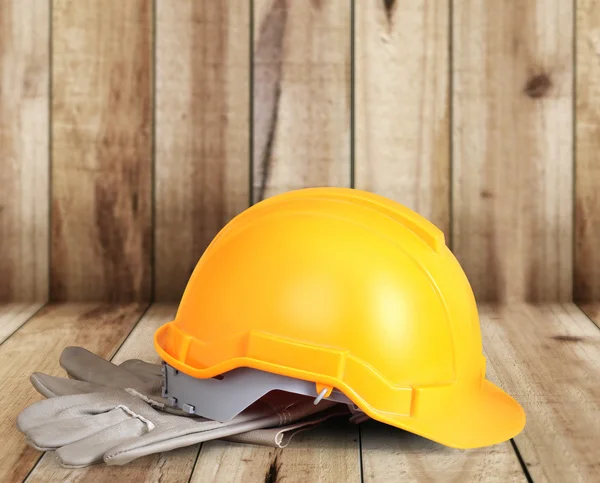 Yellow hardhat and old leather gloves — Stock Photo, Image