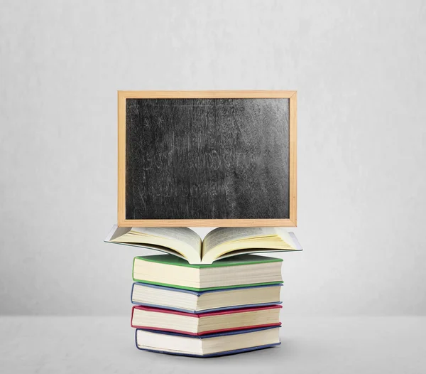 Blackboard on book  with wooden frame — Stock Photo, Image