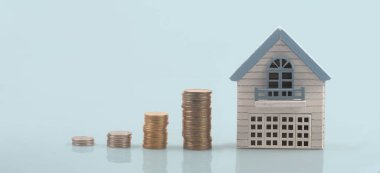 Ayrılmış minyatür ev modeli madeni paraların üzerinde maket yapıyor. gayrimenkul yatırım kavramı