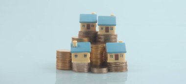 Ayrılmış minyatür ev modeli madeni paraların üzerinde maket yapıyor. gayrimenkul yatırım kavramı