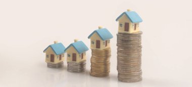 Ayrılmış minyatür ev modeli madeni paraların üzerinde maket yapıyor. gayrimenkul yatırım kavramı