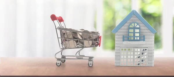 玩具购物车与模型的房子硬币和送货的概念 消费者社会趋势 — 图库照片