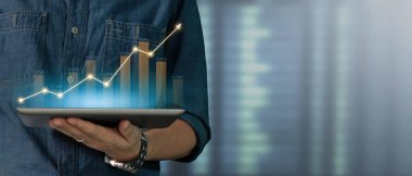 İş adamı grafik büyümesi ve tablet üzerinde yaptığı işte olumlu göstergeler artışı planlıyor