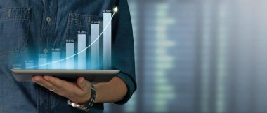İş adamı grafik büyümesi ve tablet üzerinde yaptığı işte olumlu göstergeler artışı planlıyor