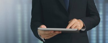 Modern teknolojileri kullanarak. Tişörtlü genç adam dijital tabletine bakıyor.