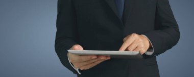 Modern teknolojileri kullanarak. Tişörtlü genç adam dijital tabletine bakıyor.