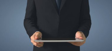 Modern teknolojileri kullanarak. Tişörtlü genç adam dijital tabletine bakıyor.