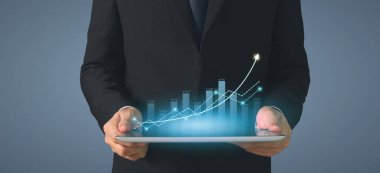 İşadamı, elinde tabletle iş yerinde grafik büyümesi ve grafik artışı planlıyor