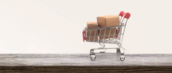 Toy shopping cart with boxes shopping and delivery concept. Consumer society trend