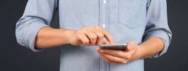 Akıllı telefonu elinde tutan ve ekrana dokunan adam.