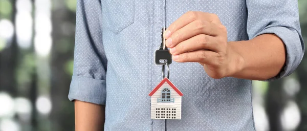 Real estate agent handing over a house keys in hand