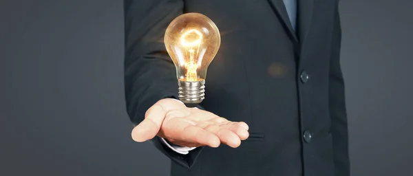 人間は革新的な技術と創造性を手に電球を保持します — ストック写真