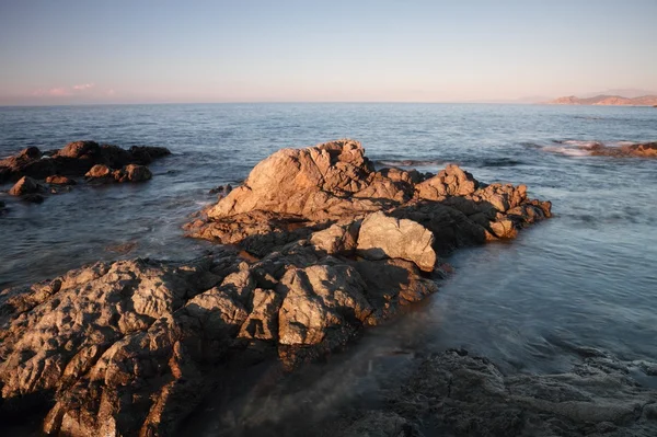 Deniz alacakaranlıkta kayalarda coriscan — Stok fotoğraf