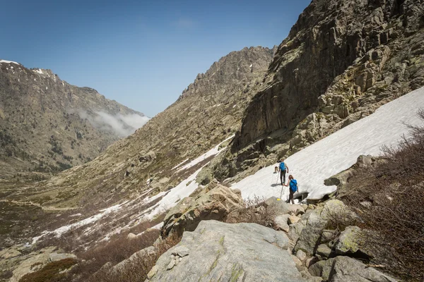 Wandelaars doorlopen sneeuw in de buurt van lac de melo in corsica — Stockfoto