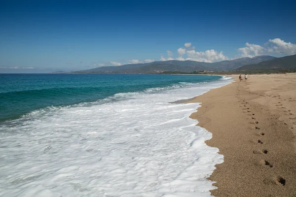 Dos personas caminando por la playa de Sagone en Córcega — Foto de Stock